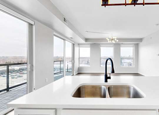 A modern kitchen with a large island and a stainless steel sink.