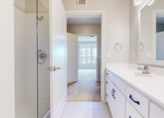 a bathroom with large vanity and glass standing shower