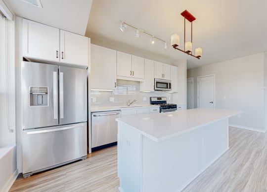 a large white kitchen with stainless steel appliances