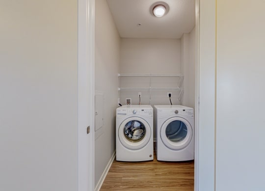 a designated laundry room with side by side washer and dryer and built in wire shelving