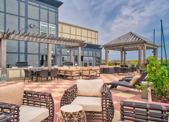 a rooftop patio with chairs and tables and grill stations