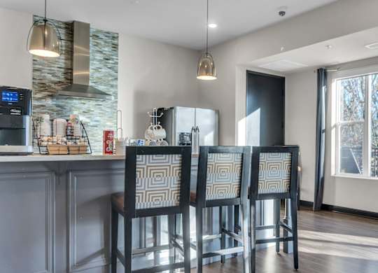 A kitchen with a bar area and four chairs.