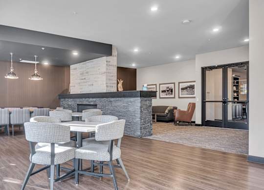 A modern dining room with a fireplace and chairs.
