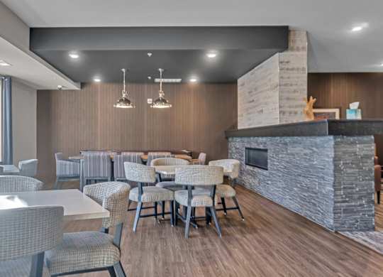 A modern dining room with a stone fireplace and wooden floors.