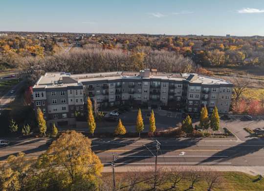 A large apartment complex surrounded by trees with autumn leaves.