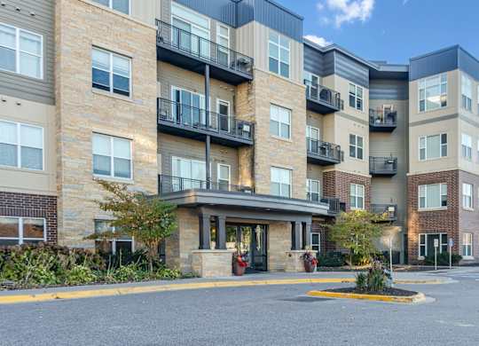 A large apartment complex with a parking lot in front.