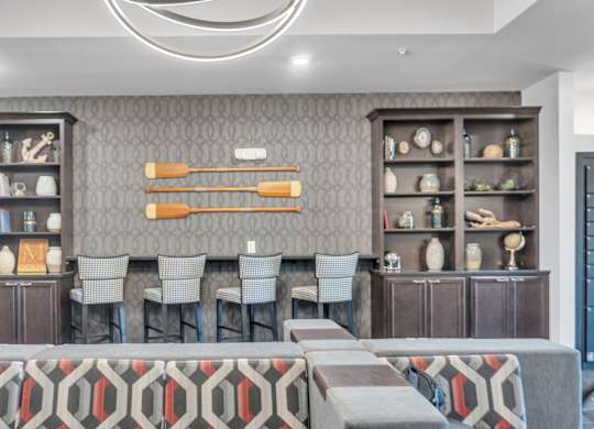 A modern dining room with a grey and red patterned bench and a grey and red patterned rug.