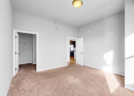 A room with white walls and carpeted floor with a light on.
