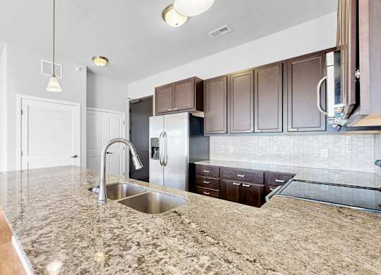 A kitchen with granite countertops and stainless steel appliances.