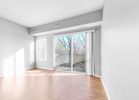 A room with a sliding glass door leading to a balcony.