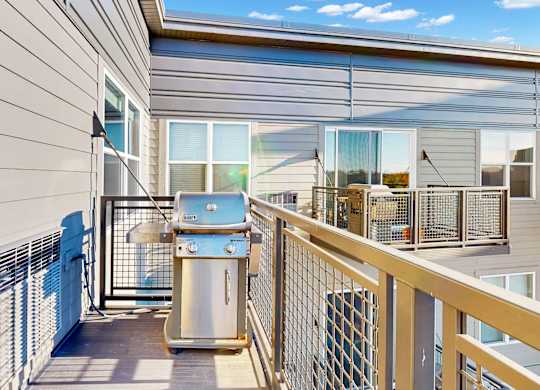 A balcony with a railing and a trash can.