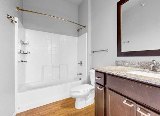A bathroom with a white toilet and a marble countertop.