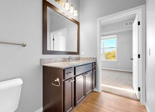 A bathroom with a white tub and a brown vanity.