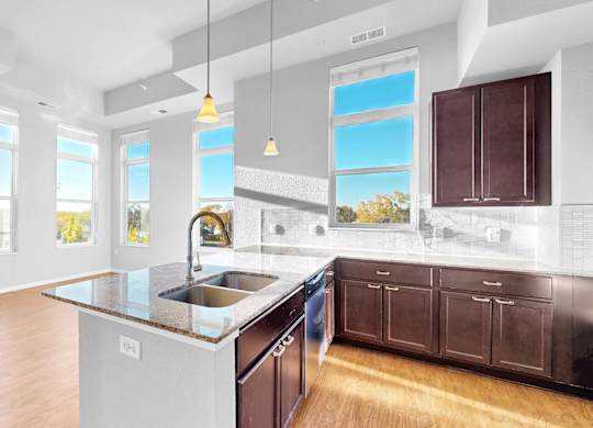 A kitchen with a large island and wooden cabinets.