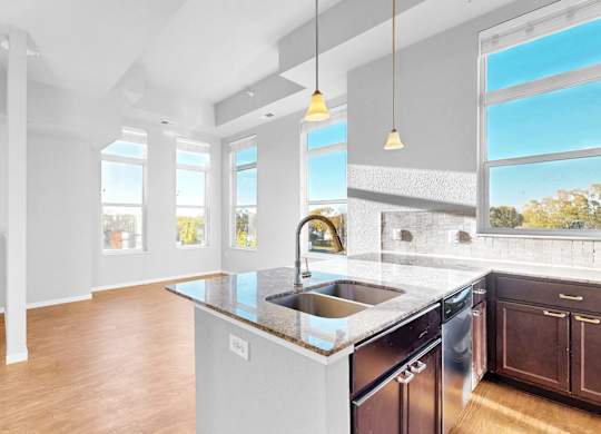 A modern kitchen with a large island and stainless steel appliances.