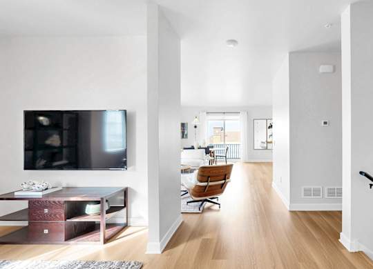 A modern living room with a television and a chair.at Field and Grove Townhomes of Champlin, Minnesota, 55316