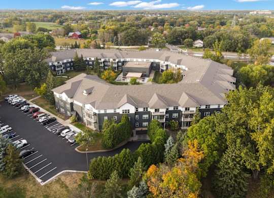 A large building surrounded by trees and a parking lot.