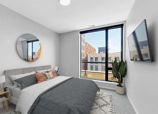 A bedroom with a large bed and a flat screen TV mounted on the wall.