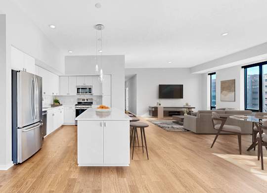 A modern kitchen with a white island and stainless steel appliances.