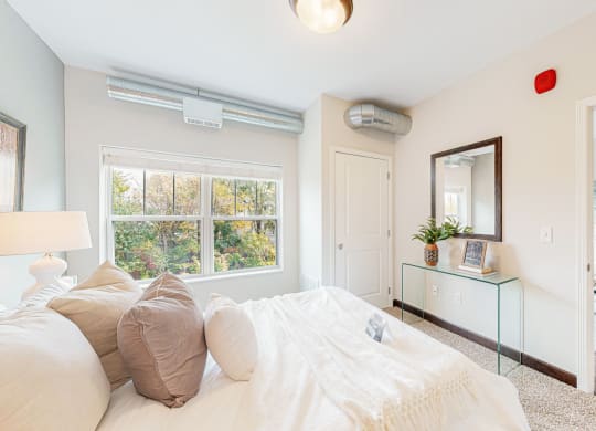 a bedroom with a bed and a large window