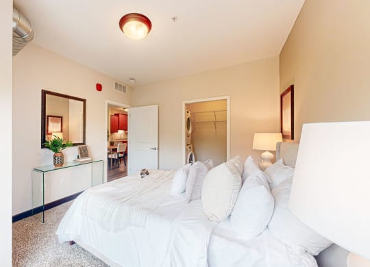 a bedroom with a large white bed and a bathroom