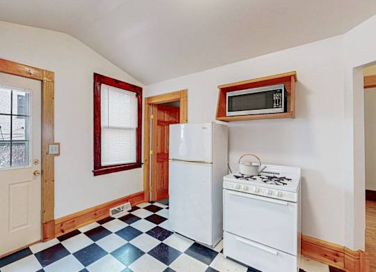 A kitchen with a white stove and a white refrigerator.