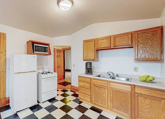 A kitchen with white appliances and wooden cabinets.