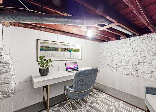 A room with a stone wall and a chair.