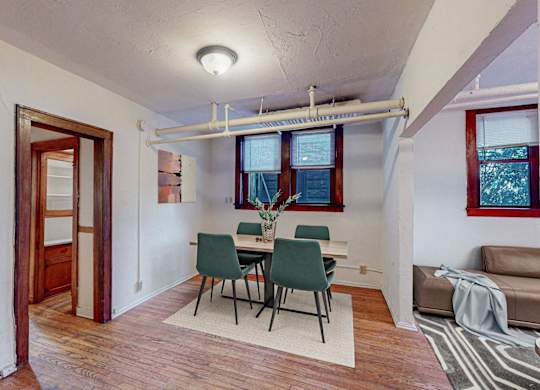 A room with a dining table and chairs.
