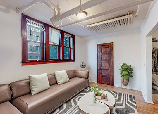 A living room with a brown couch and a white coffee table.