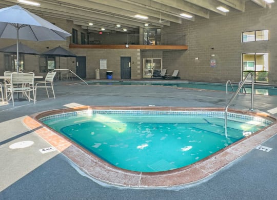 indoor spa and pool with seating and balcony