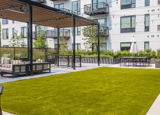 an outdoor lounge area with tables and chairs on a sunny day at The Mason, Minnesota