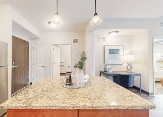 a kitchen with a granite counter top and a stainless steel refrigerator