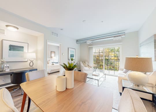 a living room with dining table and desk