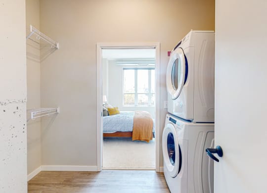 a bedroom with a large window and a washer and dryer