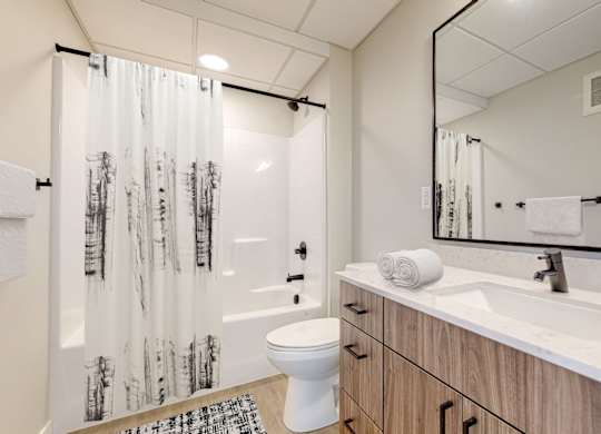 a bathroom with a toilet sink and shower in a 555 waverly unit