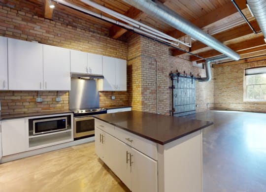a kitchen with a large island and brick walls
