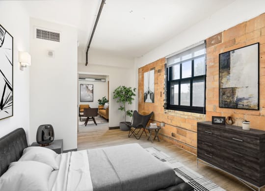 a bedroom with a bed and a exposed brick wall