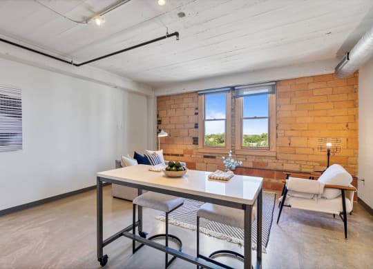 a dining room with a table and chairs and a brick wall