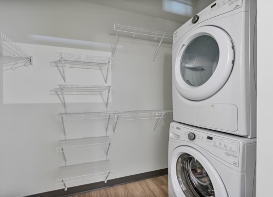 a washer and dryer in a laundry room with shelves and a dryer