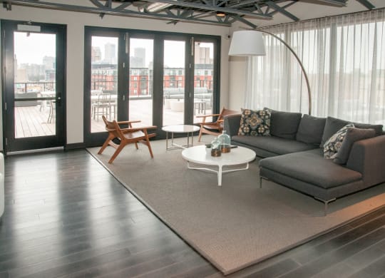 Community Room with Large Grey Sectional And Floor to Ceiling Windows at 700 Central Apartments, Minneapolis, 55414