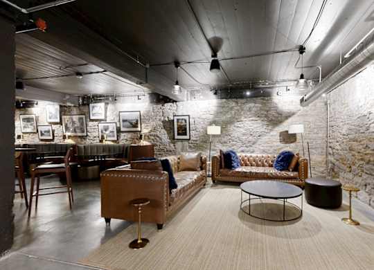 A modern living room with a stone wall and a variety of furniture.