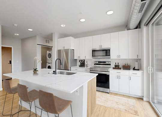 A modern kitchen with white cabinets and a large island.