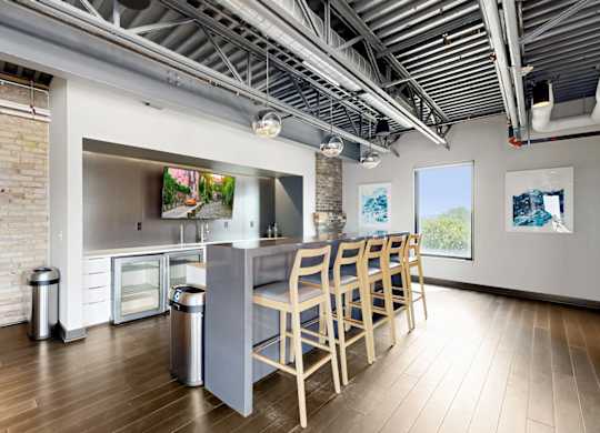 A kitchen with a long table and chairs.