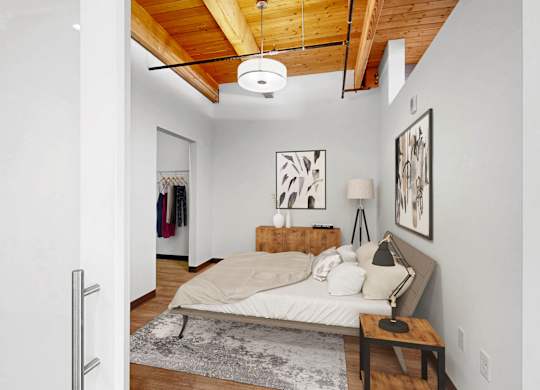 A bedroom with a bed, a bench, and pictures on the wall.