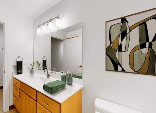 A bathroom with a white sink and a green towel.