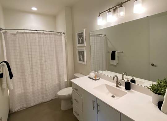 A bathroom with a white sink and a white toilet.