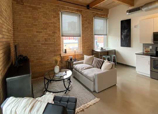 A living room with a couch, chair, and a table with a blanket on it.