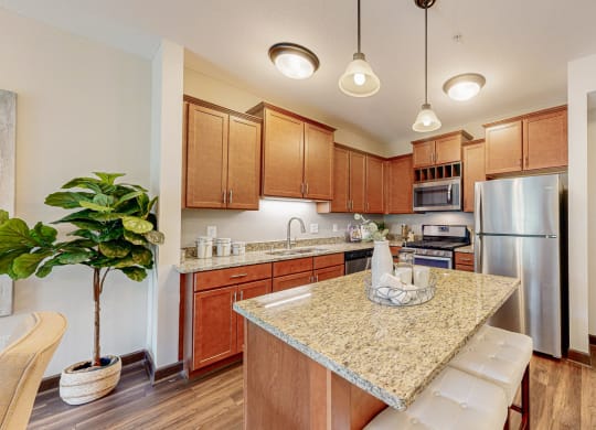 a kitchen with a granite counter top and a stainless steel refrigerator