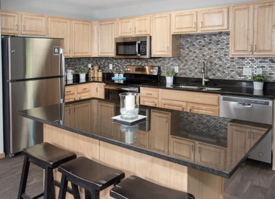 kitchen with island, granite countertop, tile backsplash